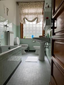 a bathroom with a tub and a sink and a toilet at CASA DELLA PIAZZA in Bagnone