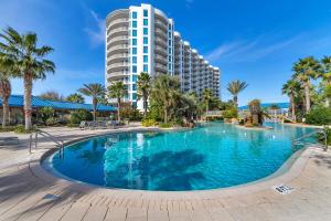 a large swimming pool with a tall building in the background at Palms of Destin 2803 in Destin