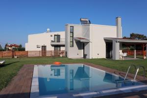 a house with a swimming pool in front of a house at OLYMPUS Paradise 1 in Skotina