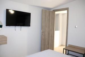 a bedroom with a flat screen tv on the wall at OLYMPUS Paradise 1 in Skotína
