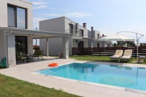 a swimming pool in front of a house at OLYMPUS Paradise 2 in Skotina