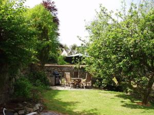 a garden with a table and chairs in a yard at Abbey Green, New Abbey, Dumfries and Galloway in Dumfries