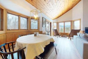 uma sala de jantar com uma mesa branca e cadeiras em White Mountain Chalet em Bartlett