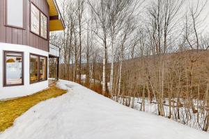 una casa en el bosque en la nieve en White Mountain Chalet en Bartlett