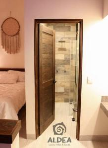 a bedroom with a glass door leading to a shower at Villa Naj´Lujosa Alberca privada in San Martín de las Pirámides