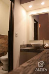 un bagno con lavandino, WC e specchio di Villa Naj´Lujosa Alberca privada a San Martín de las Pirámides Altre 29 foto
