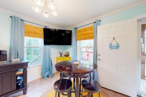 a dining room with a table and chairs and a tv at O'Hara Haven in Dauphin Island