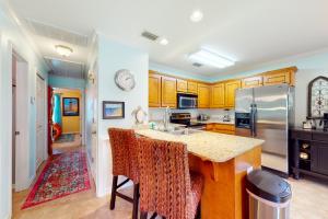 a kitchen with wooden cabinets and a counter top at O'Hara Haven in Dauphin Island