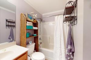 a bathroom with a shower curtain and a toilet at O'Hara Haven in Dauphin Island +22 photos