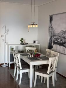 a dining room with a white table and chairs at Blue Vision in Nea Makri