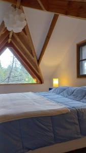 1 dormitorio con 1 cama grande y ventana en Casa de Montaña en San Carlos de Bariloche