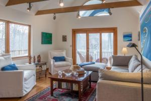 a living room with couches and a table at Harbor Village House in Rockport