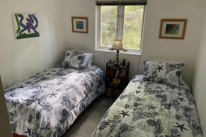 a bedroom with two beds and a window at Harbor Village House in Rockport