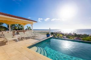 a swimming pool with a view of the ocean at Coral Estate Holidays in Willibrordus