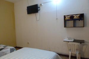 a bedroom with a bed and a tv on the wall at Pirhua Hotel Boutique in Piura