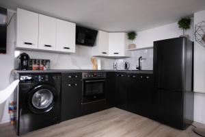 uma cozinha com um frigorífico preto e uma máquina de lavar louça em 80qm - 4 rooms - privat parking - Keller-Basement - MalliBase Apartments em Hanôver