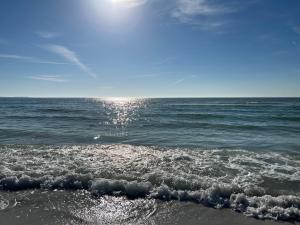 a beach with the sun shining on the water at Updated St. Pete Beachside Condo in St. Pete Beach