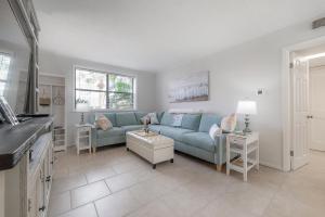 sala de estar con sofá azul y mesa en Updated St. Pete Beachside Condo, en St Pete Beach