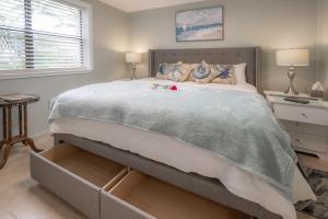 a bedroom with a large bed with a drawers at Updated St. Pete Beachside Condo in St. Pete Beach