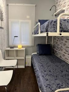 ein kleines Schlafzimmer mit einem Etagenbett und einem Schreibtisch in der Unterkunft Coqueto apartamento muy céntrico in Madrid