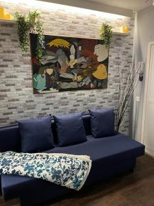 a blue couch in a living room with a painting at Coqueto apartamento muy céntrico in Madrid
