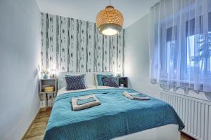 a bedroom with a bed with a blue comforter at HAROL Home & Bike in Fertőrákos