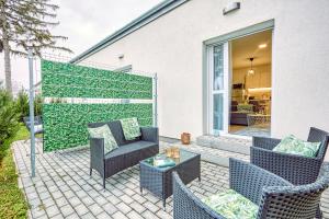 a patio with wicker chairs and a fence at HAROL Home & Bike in Fertőrákos