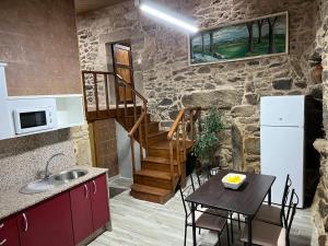 eine Küche und ein Esszimmer mit einem Tisch und einem Kühlschrank in der Unterkunft Casa Xulián in Monterroso