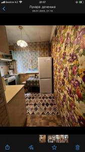 a kitchen with a refrigerator in the corner of a kitchen at Apartment on Akhmetova 10 in Almaty