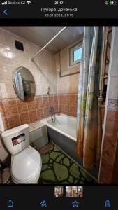 a bathroom with a toilet and a bath tub at Apartment on Akhmetova 10 in Almaty