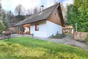 a small white house with a black roof at Wooden house in the heart of the Giant Mountains with own hill in Víchová nad Jizerou