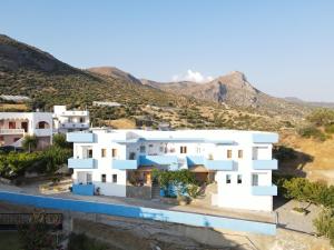 a view of a white house with mountains in the background at Panorama Apartments in Kastrí