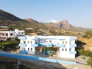a view of a white house with mountains in the background at Panorama Melina Apartments in Kastrí