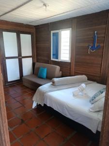 1 dormitorio con cama, sofá y ventanas en Cabañas Navegar- El peñol, Guatape, en Guatapé