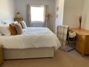 a bedroom with a bed and a desk and a window at Ferry Rd by Westcountry SA in Plymouth