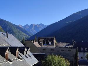 a group of buildings with mountains in the background at L'Alexiane, Centre Luchon, parking gratuit, wifi in Luchon
