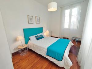 a bedroom with a large bed with a blue blanket at L'Alexiane, Centre Luchon, parking gratuit, wifi in Luchon