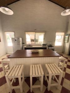 a kitchen with a large island with two benches at Chacra en Emprendimiento Tierra de Caballos in Colonia Estrella