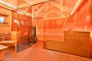 una sauna con paredes de madera, una silla y una mesa en Wooden house in the heart of the Giant Mountains with own hill, en Víchová nad Jizerou