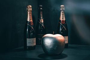 Dwie butelki szampana i jabłko na stole. w obiekcie Luxus Loft Whirlpool Designer Küche Bad w mieście Herdecke