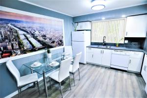 a kitchen with a glass table and white appliances at The Modern Spot in Winnipeg