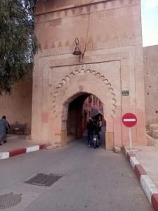 een boog in een gebouw waar mensen doorheen lopen bij Dar 36 LAKSIBA in Marrakesh