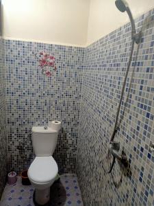 een badkamer met een toilet en een blauwe betegelde muur bij Dar 36 LAKSIBA in Marrakesh