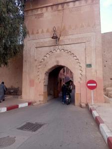 een persoon die door een boog in een gebouw loopt bij Dar 36 LAKSIBA in Marrakesh