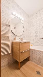 a bathroom with a sink and a mirror and a tub at Orange Onix Apartaments in Bucharest
