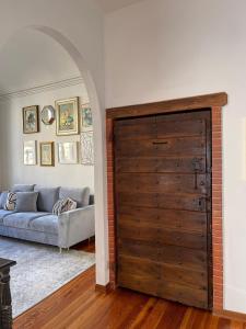 een grote houten deur in een woonkamer met een bank bij Large, luxurious family apartment in Biella's historic center in Biella