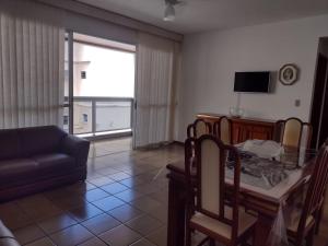 a living room with a glass table and a couch at Apartamento Praia do Forte Familiar com piscina in CFB