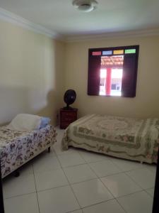 ein Schlafzimmer mit zwei Betten und einem Fenster in der Unterkunft Casa veraneio em Canto de Arembepe in Camaçari + 10 Fotos