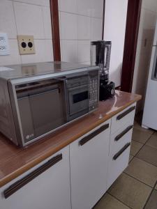 a microwave sitting on top of a counter in a kitchen at Apartamento Praia do Forte Familiar com piscina in CFB