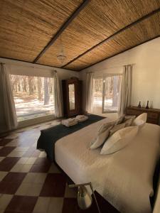 1 dormitorio con 1 cama blanca grande y ventanas en Chacra en Emprendimiento Tierra de Caballos en Colonia Estrella